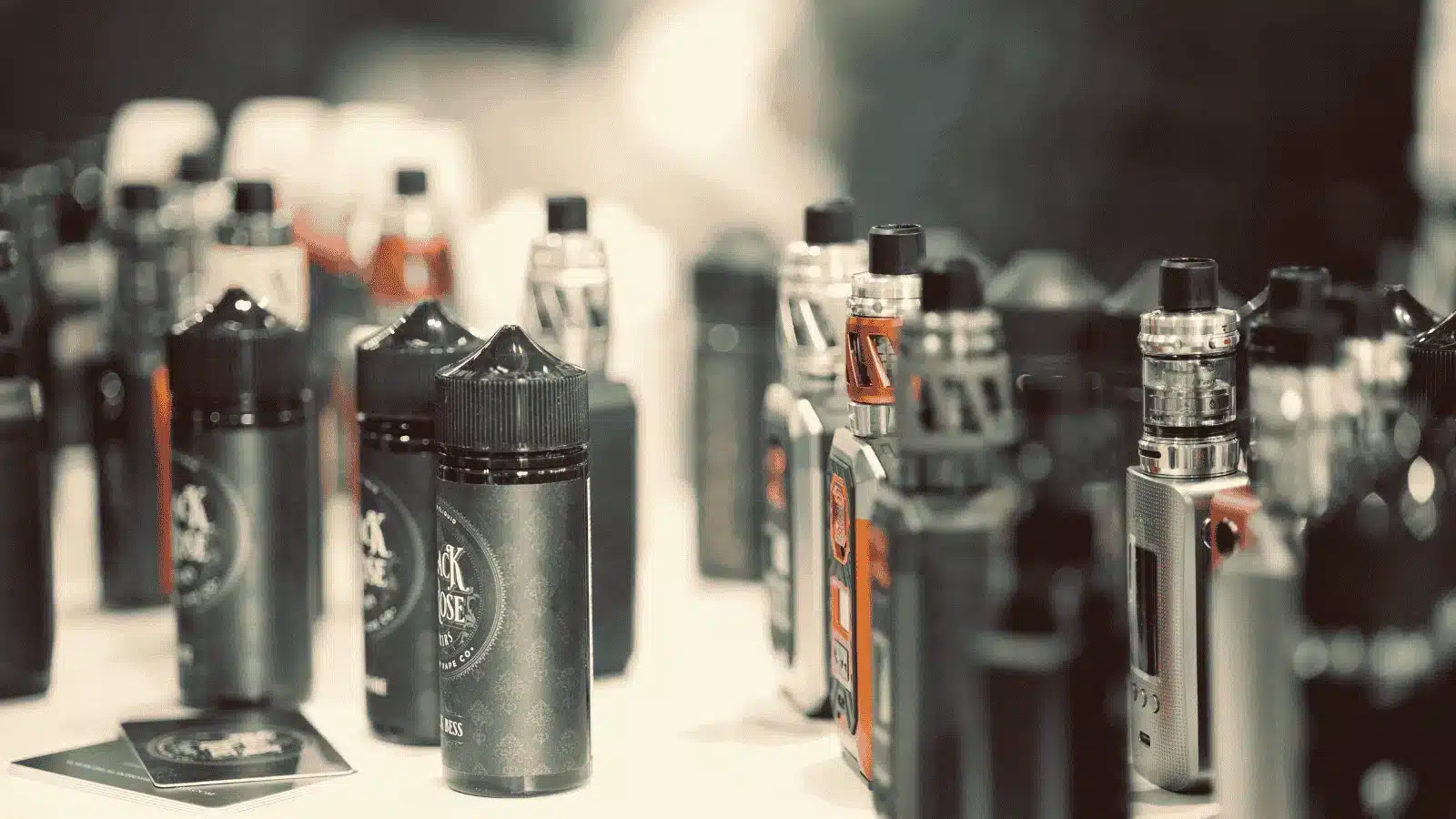 Display of various vape devices and e-liquid bottles on a counter, showcasing a selection of vaping products and accessories